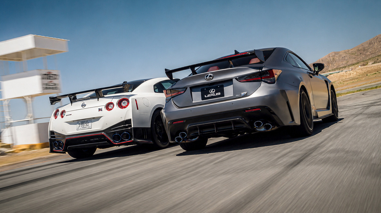Deux voitures de sport en pleine course sur une piste, une Nissan GT-R blanche et une Lexus RC F grise.