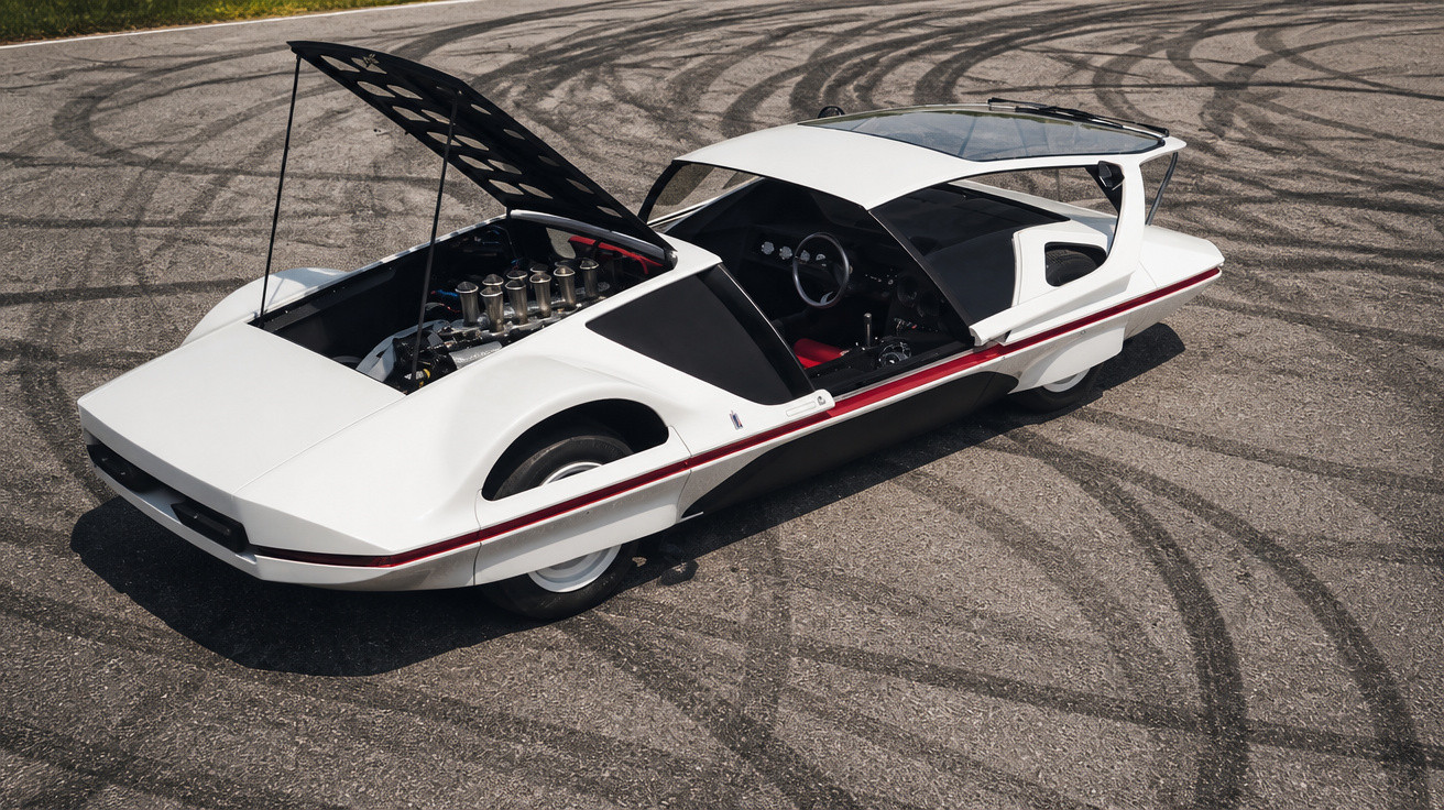 Voiture de sport blanche futuriste avec moteur exposé et traces de pneus sur l'asphalte autour.